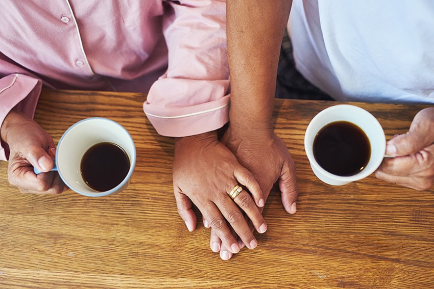 זוג עומד ליד שולחן עם כוסות קפה חצי ריקות